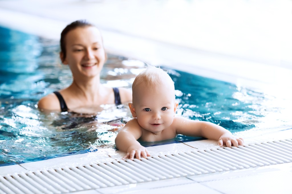 Mother instructs her 11-month-old baby to swim in a pool